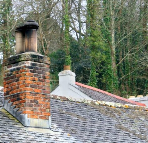 A chimney flashing on a shingled roof.