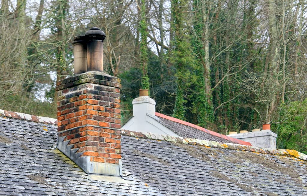 A chimney flashing on a shingled roof.