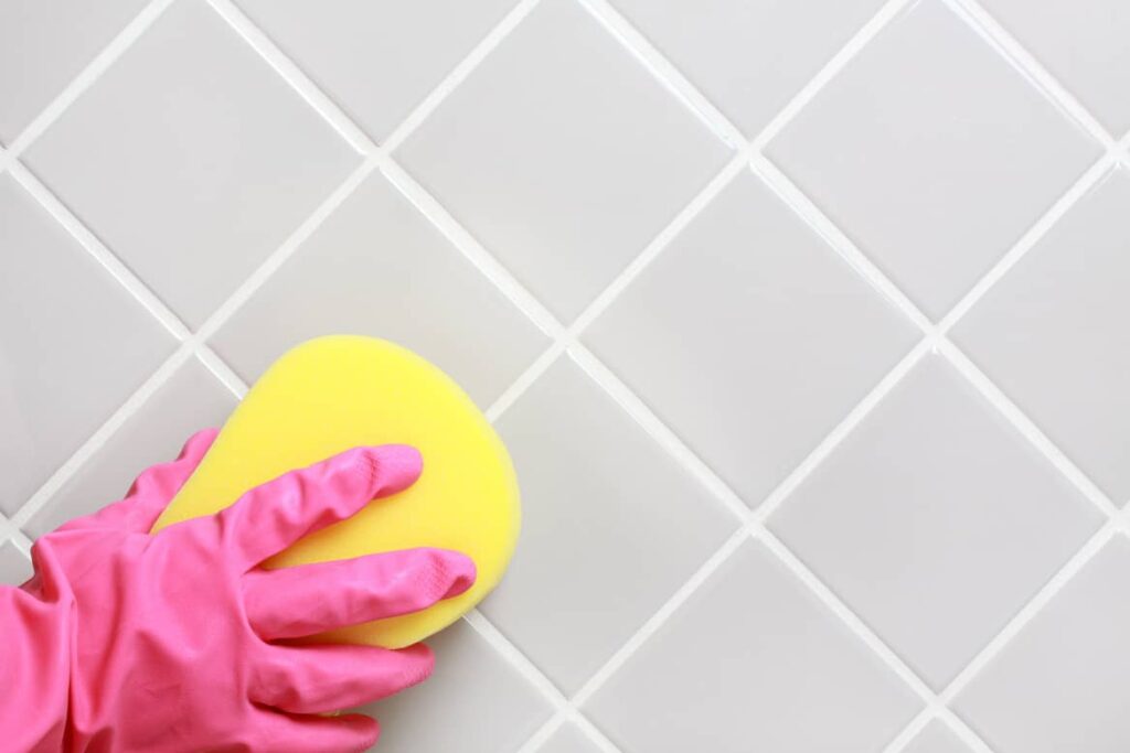 Using a damp sponge to remove excess grout is key to keeping a shiny clean tile look.