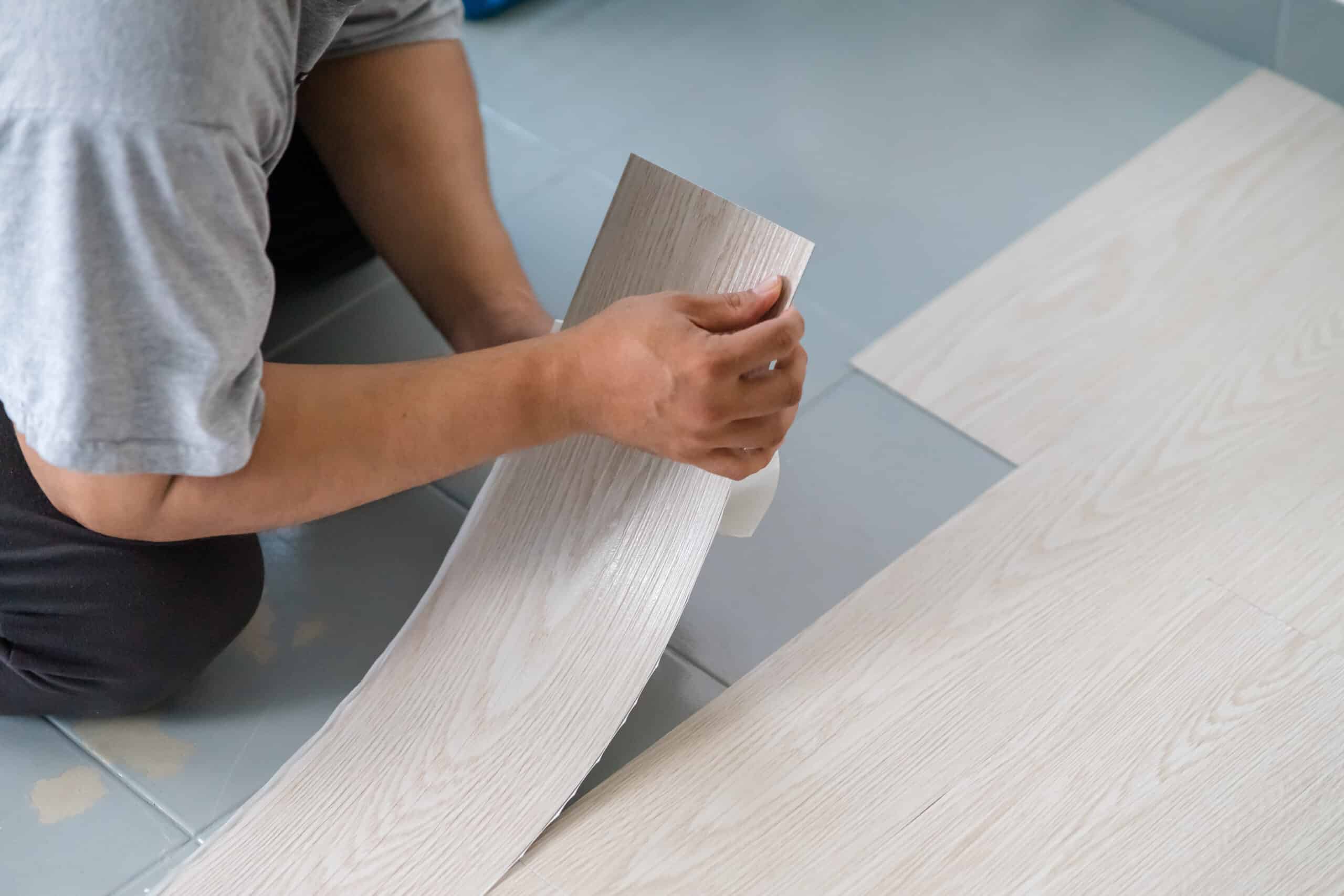 A Person Installing Peel and Stick Vinyl Flooring